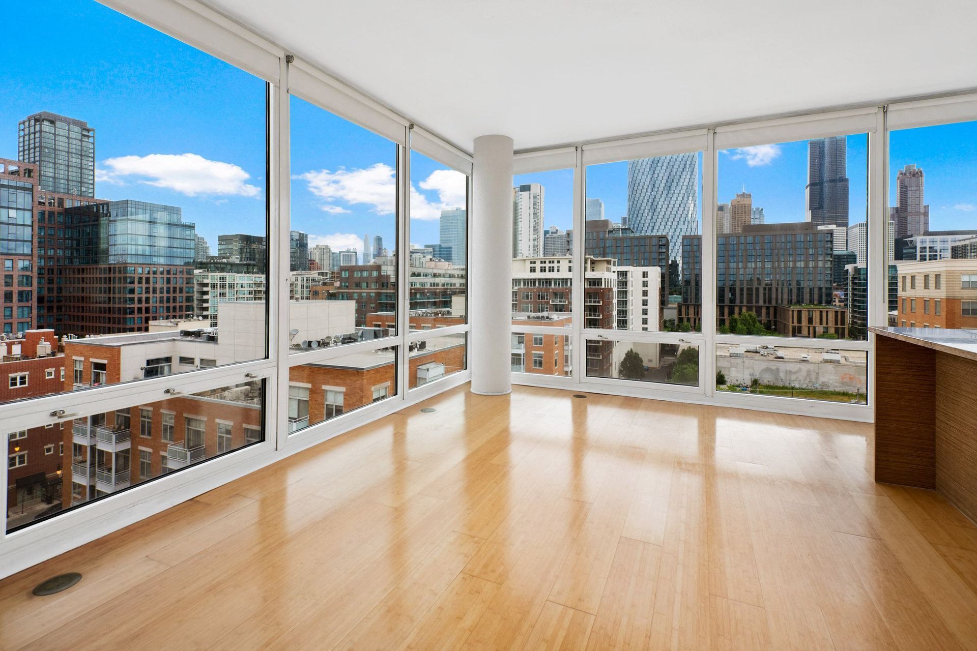 a living area with hardwood floors and large windows