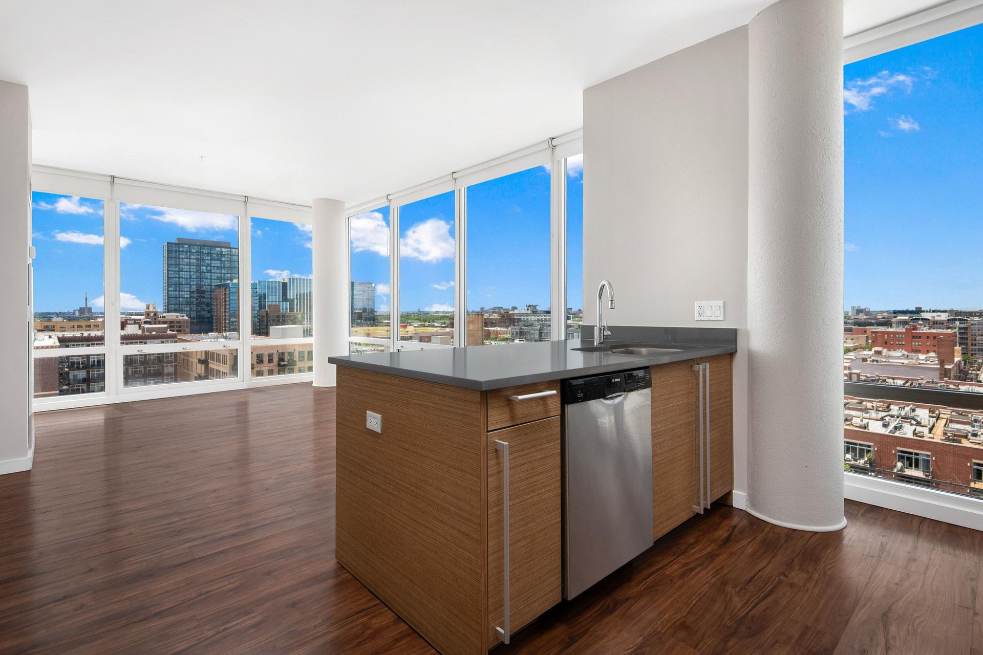 an open living room with a view of the city and a kitchen with a island