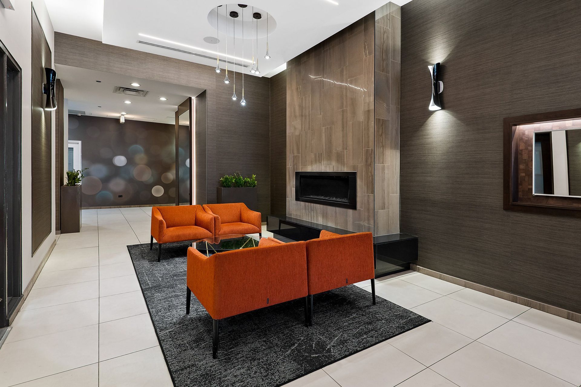 a lobby with orange couches and a fireplace