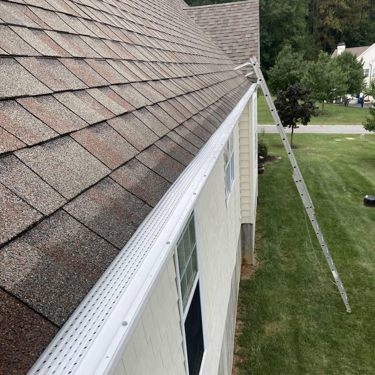 A Ladder Is Sitting On The Side Of A House Next To A Gutter — Wilmington, DE — Jennings Home Rejuvenation
