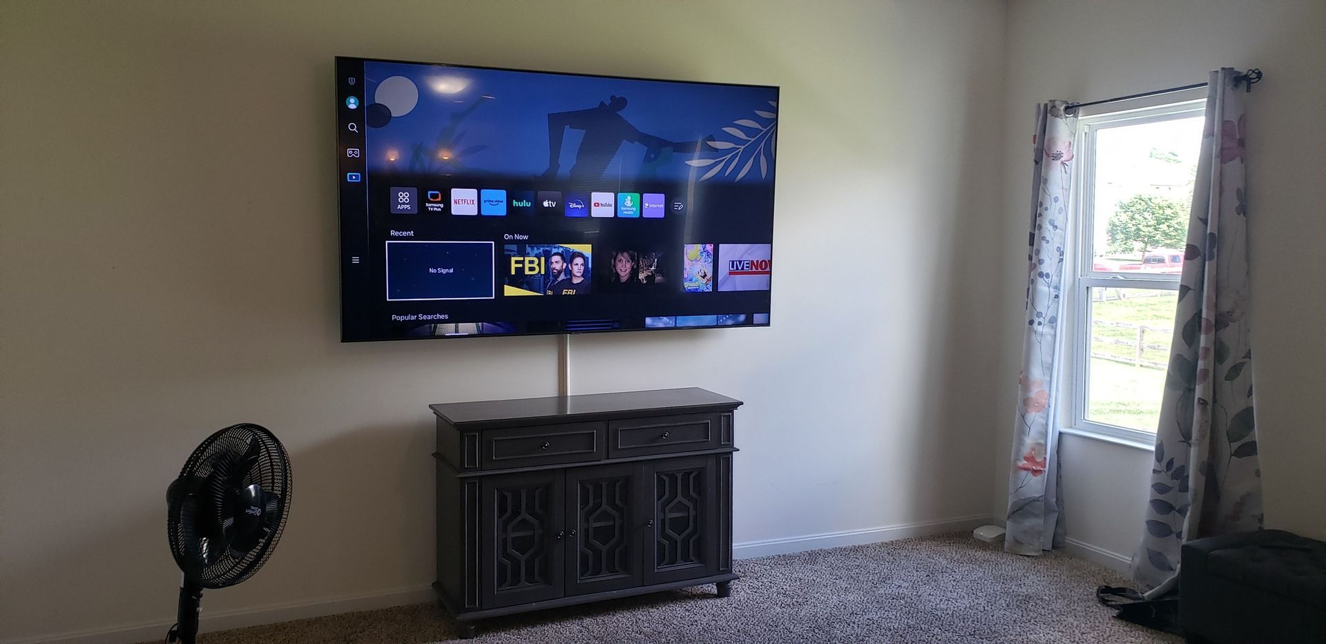 A living room with a large flat screen tv mounted on the wall.