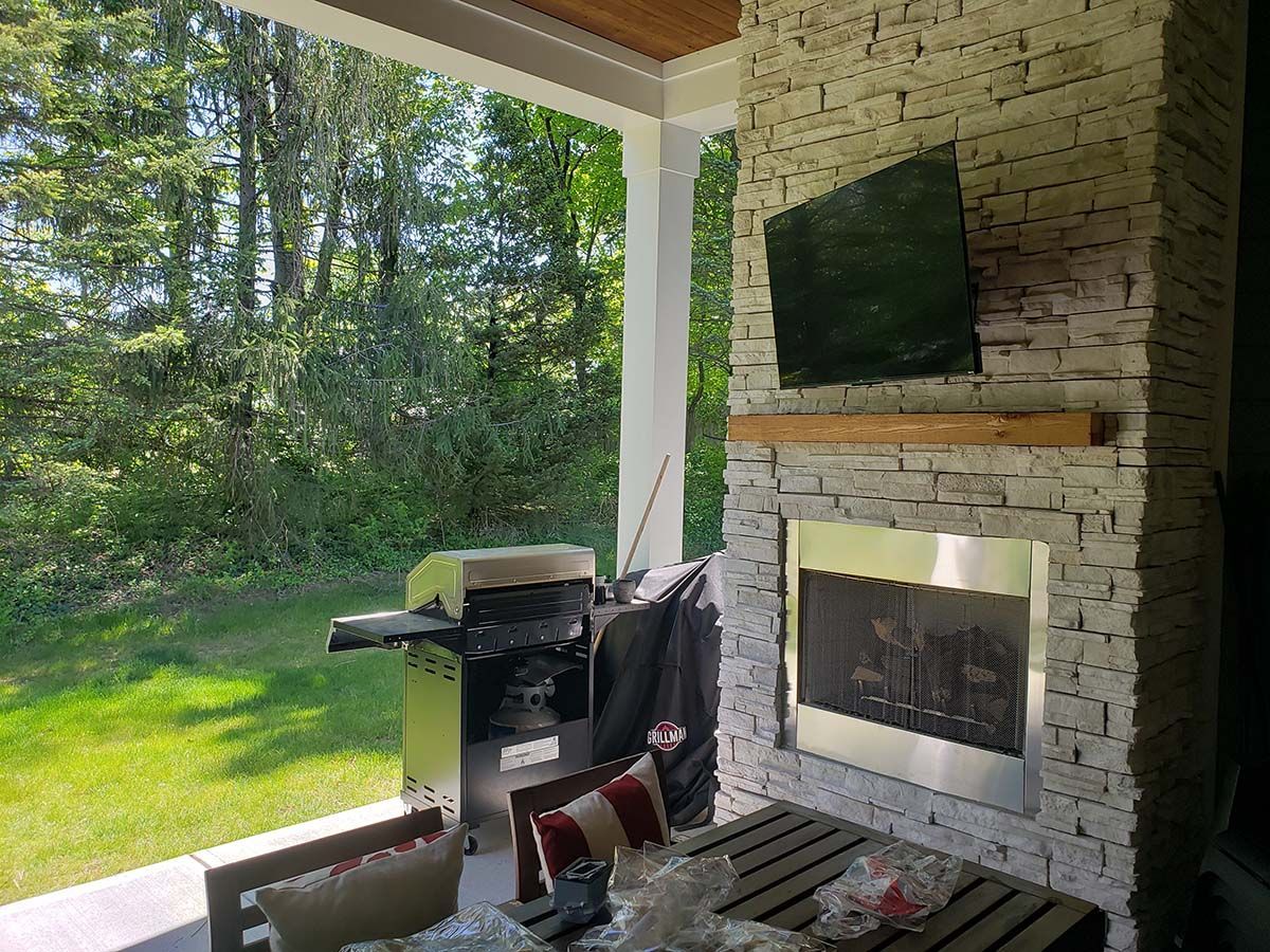 There is a fireplace and a television on the porch.
