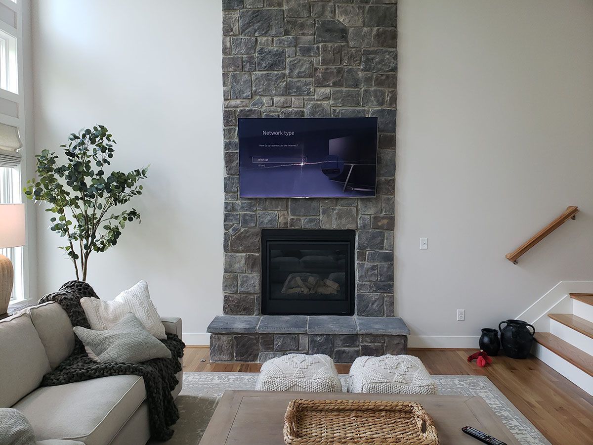 A living room with a fireplace and a flat screen tv on the wall.