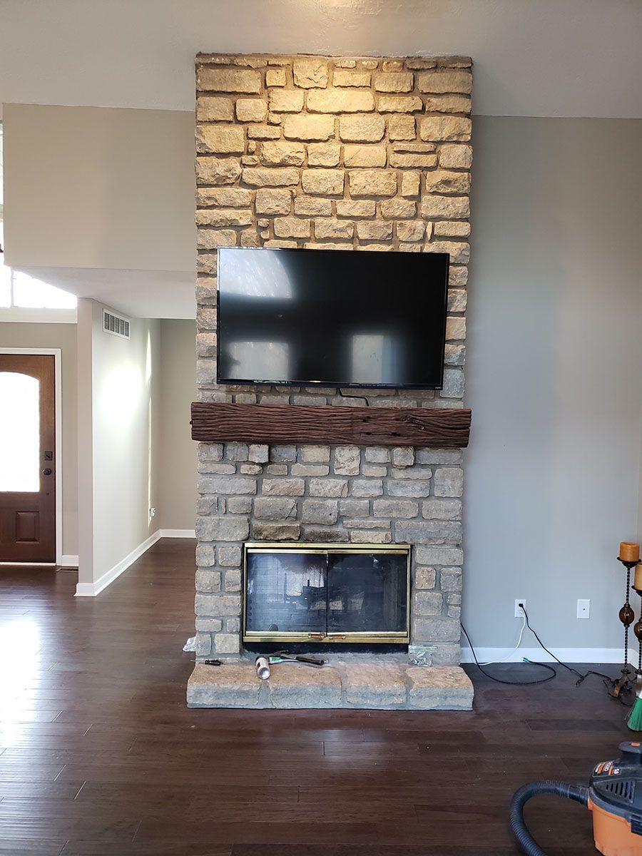 A brick fireplace with a flat screen tv mounted on the wall above it.