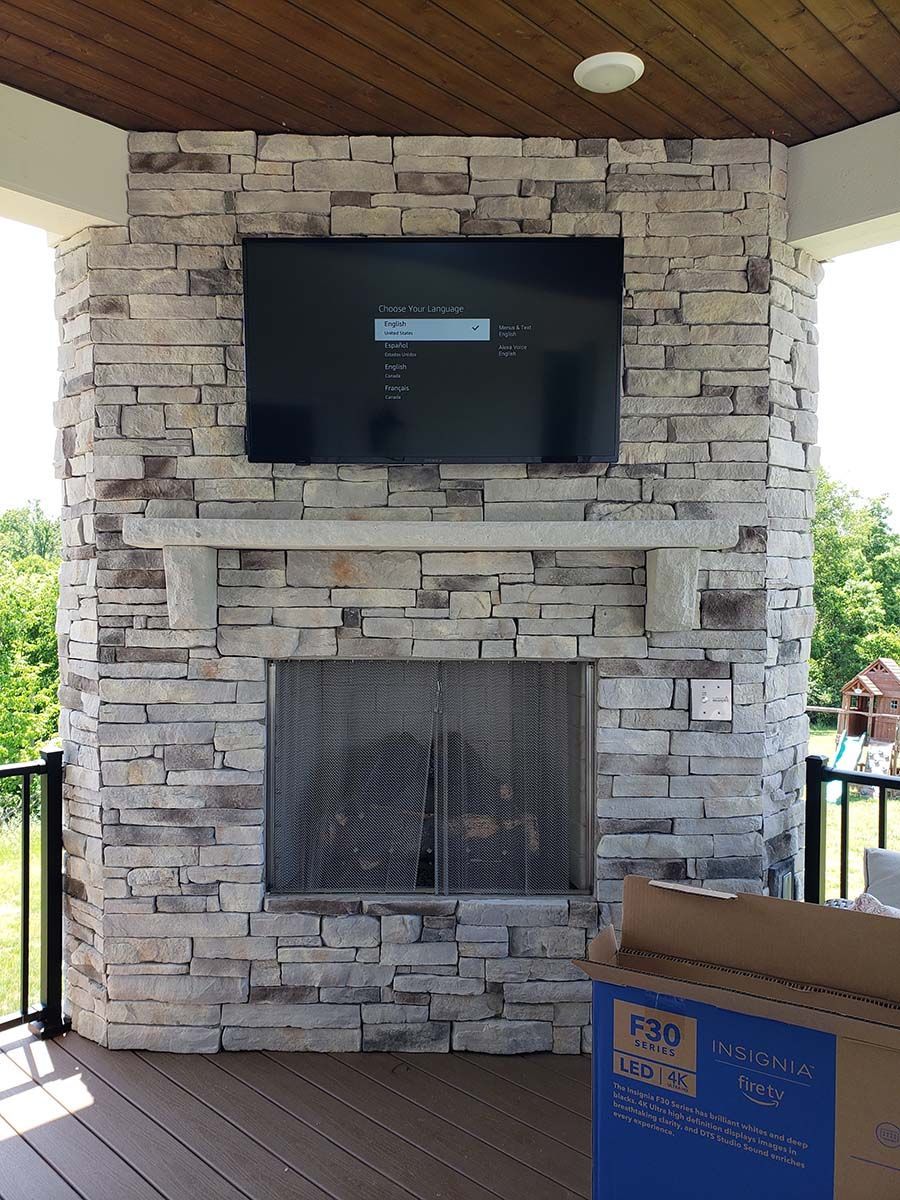 A brick fireplace with a flat screen tv mounted above it.