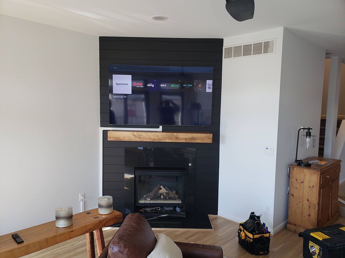 A living room with a fireplace and a flat screen tv mounted to the wall.
