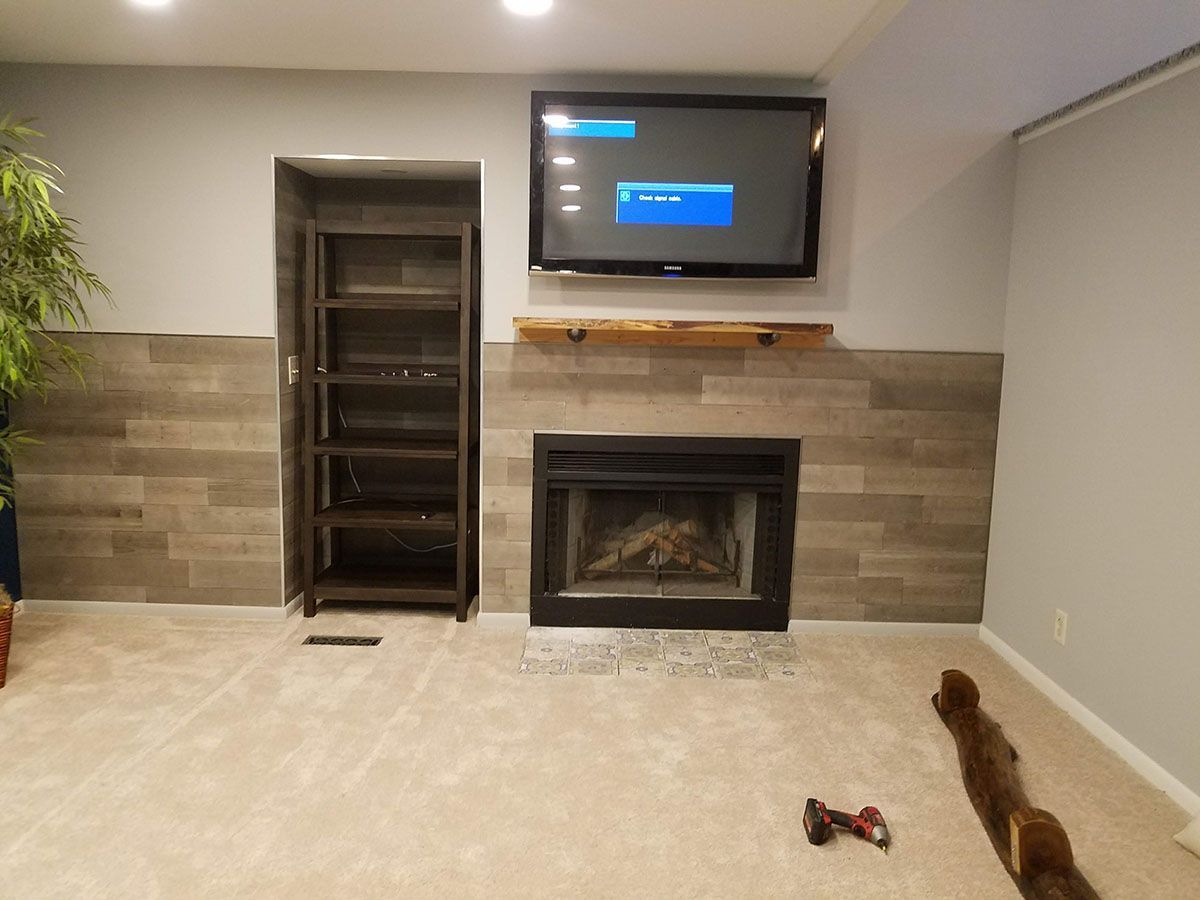 A living room with a fireplace and a flat screen tv on the wall.