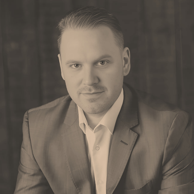 Brayden Sutton: A man in a suit and white shirt is looking at the camera