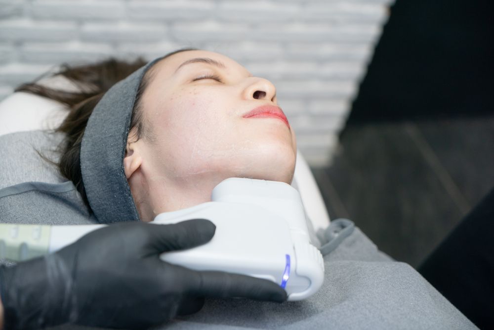 Woman Receiving a Neck Treatment With a Device; Practitioner in Black Gloves — HealthPoint Mingara In Tumbi Umbi, NSW