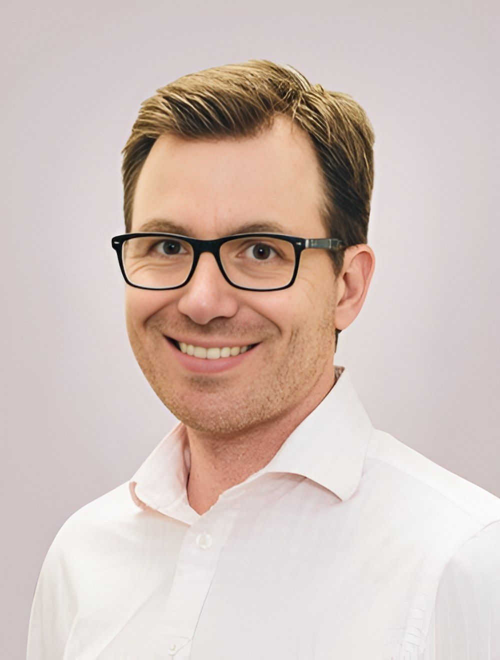 A Man Wearing Glasses And A White Shirt Is Smiling For The Camera — HealthPoint Mingara In Tumbi Umbi, NSW