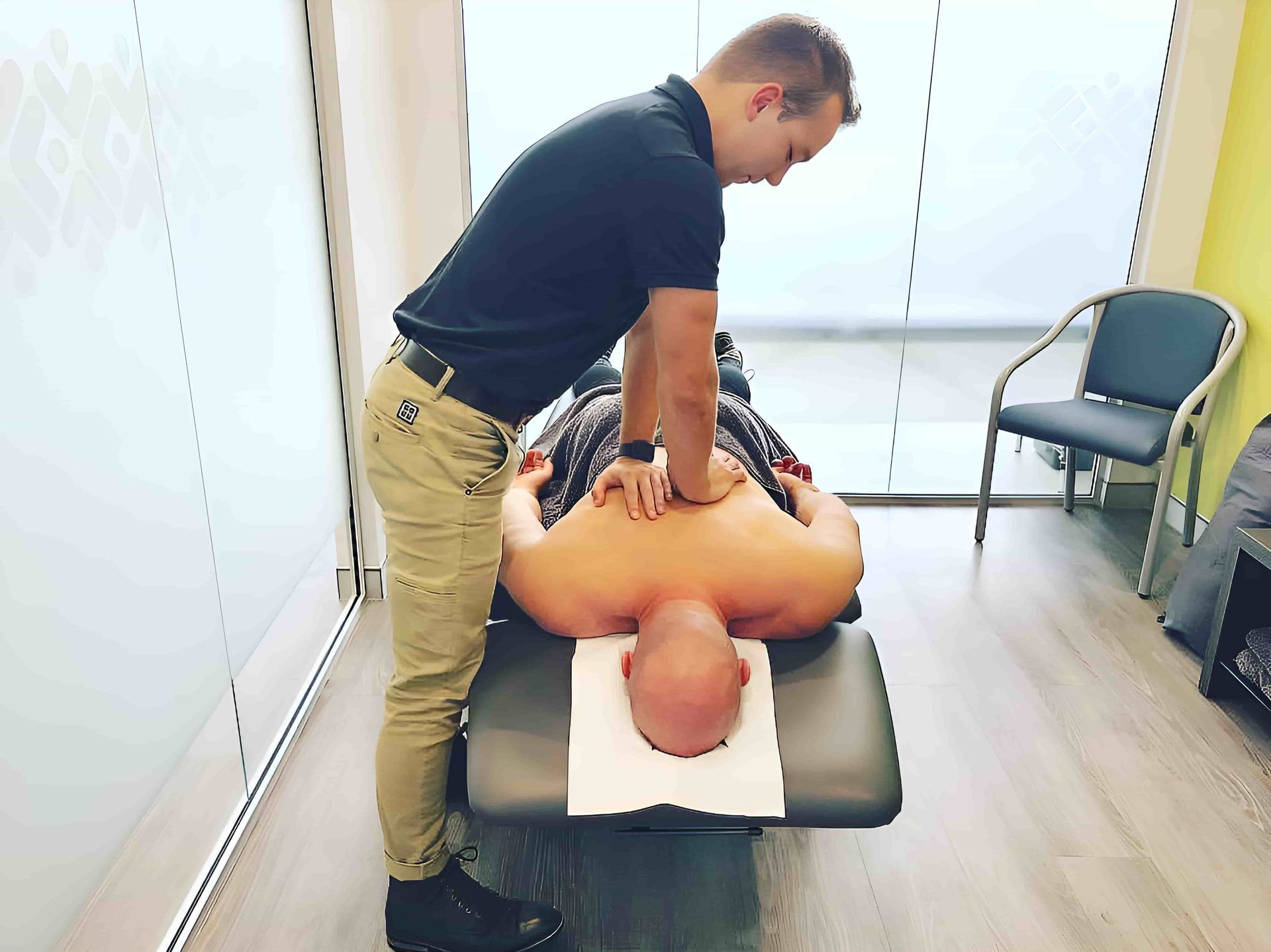 A Man Is Laying On A Bed Getting A Massage — HealthPoint Mingara In Tumbi Umbi, NSW