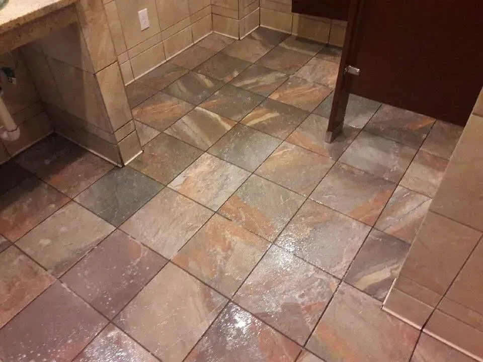 A bathroom with a tiled floor and a sink.