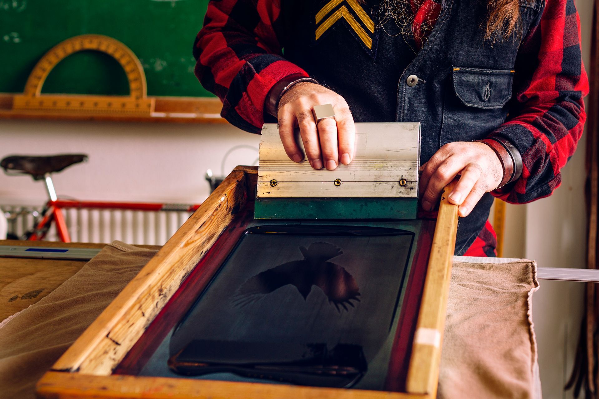 A detailed view of screen printing in progress, showcasing the craftsmanship behind custom t-shirts 