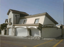 Damaged white two-story house with collapsed garage and cracked front facade after an earthquake Damaged white two-story house with collapsed garage and cracked front facade after an earthquake