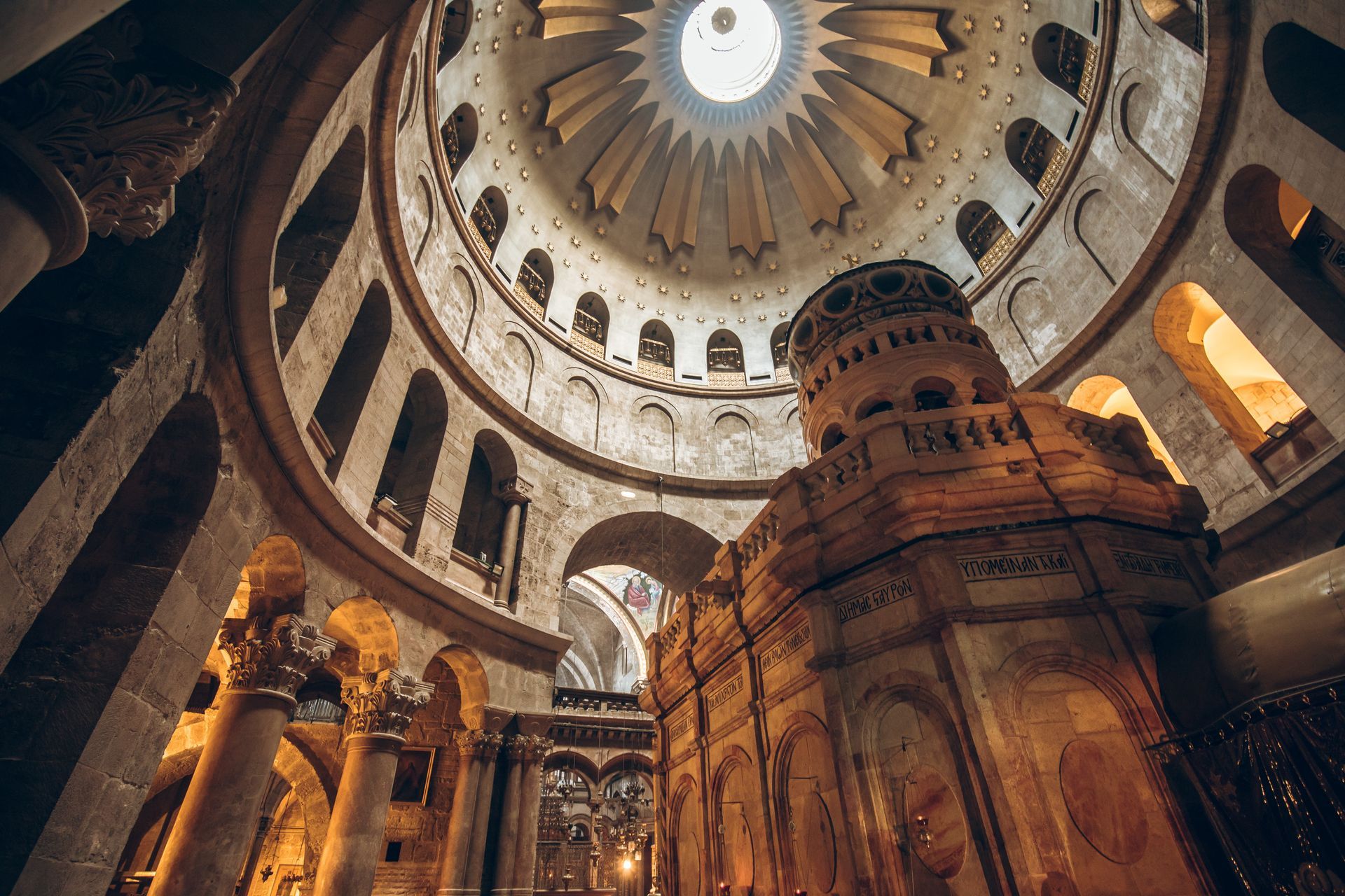 Interior of the Church of the Holy Sepulchre, Jerusalem; ornate domed ceiling and ancient architecture.