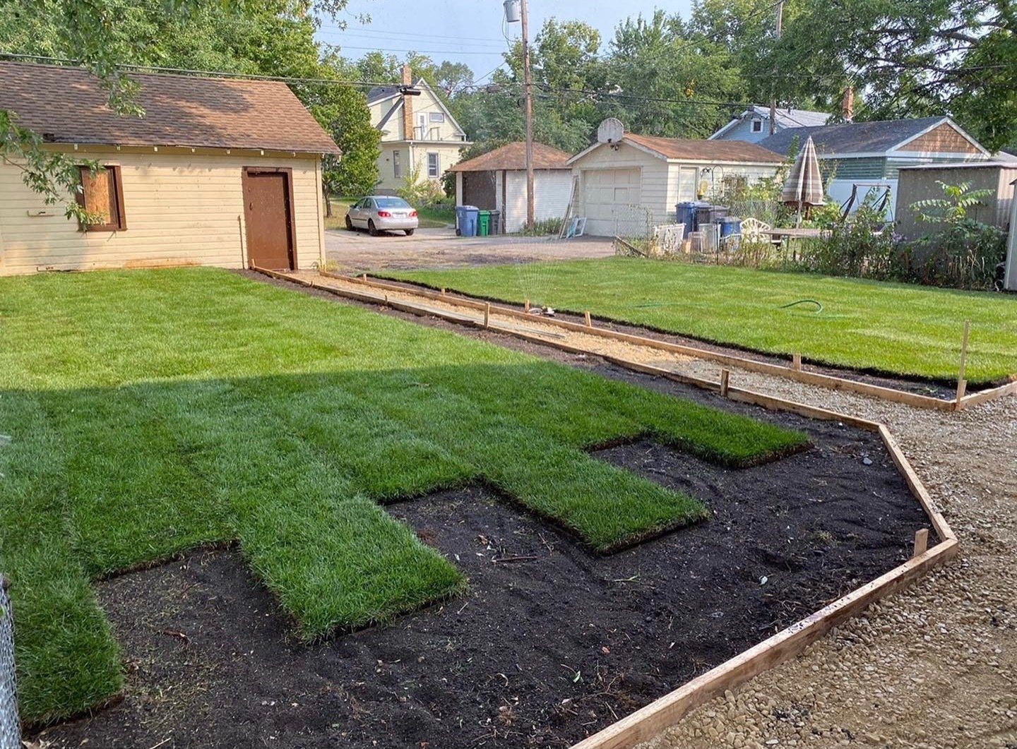 A lush green lawn is being installed in front of a house.