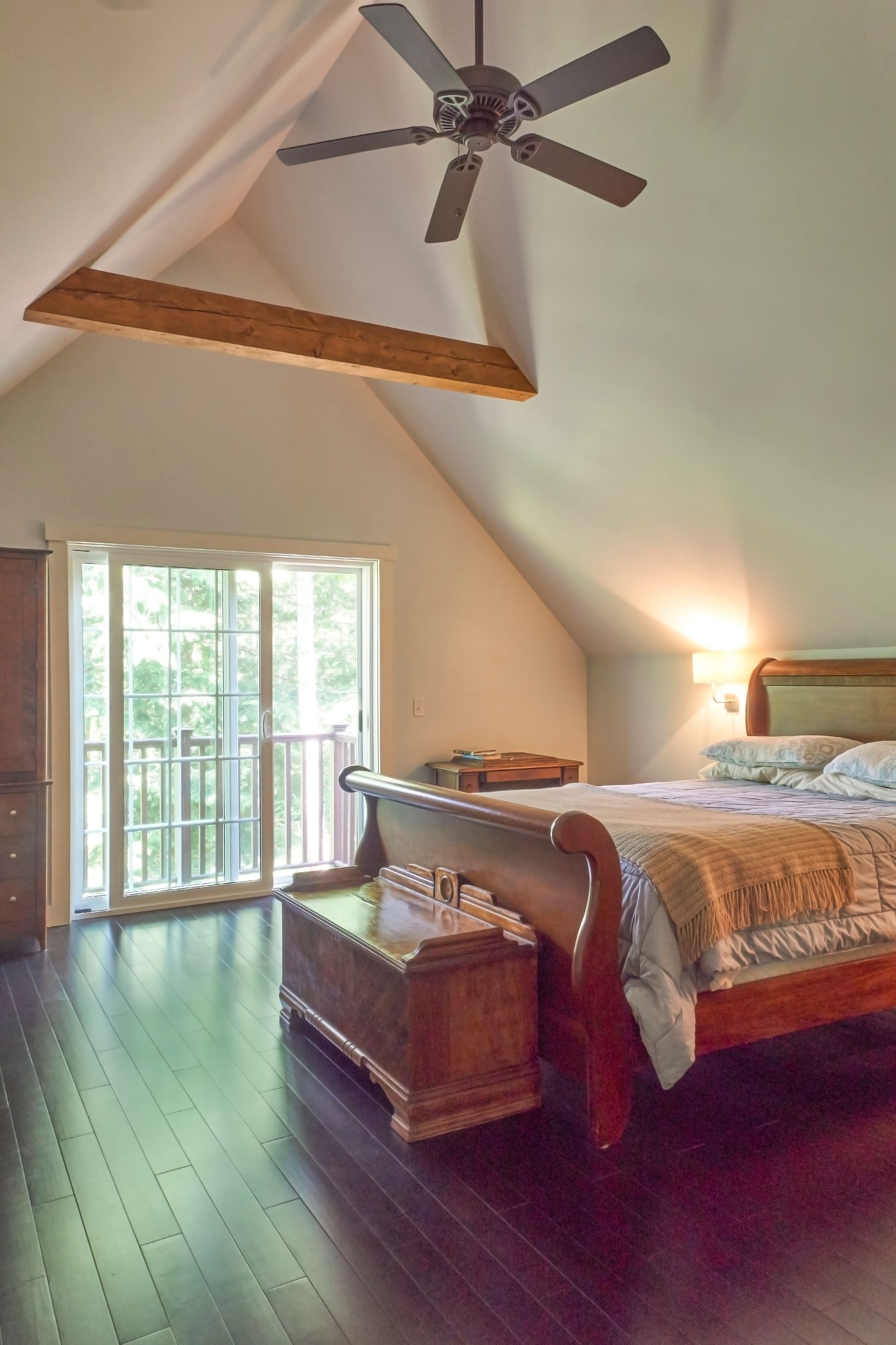 A bedroom with a large bed and a ceiling fan