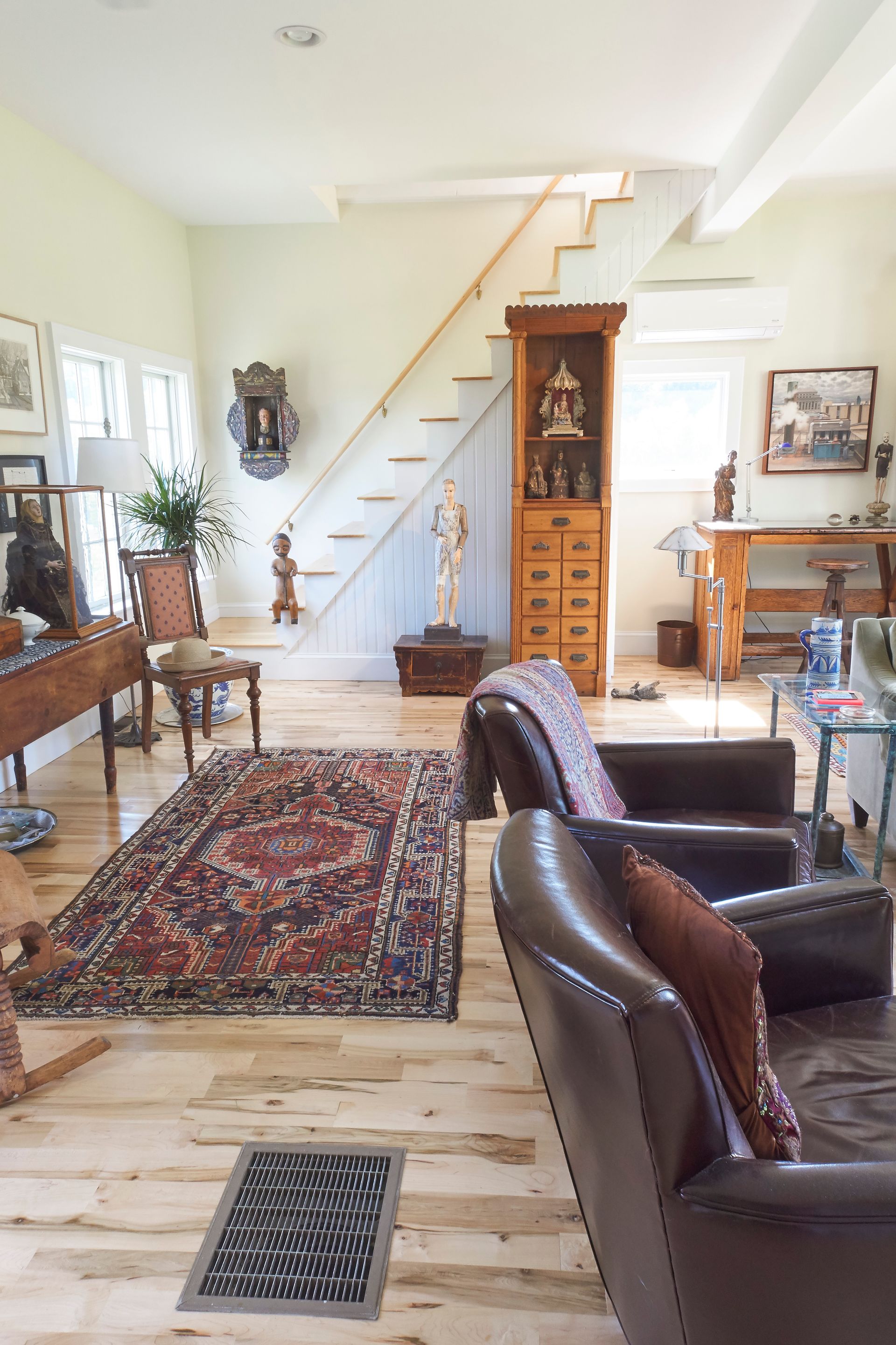 A white house with a large porch and a white pergola.