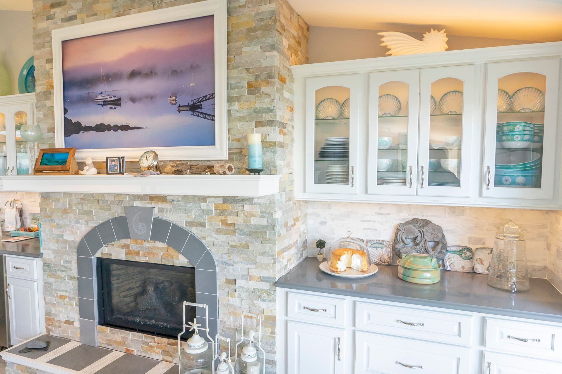 A kitchen with a fireplace and a picture on the wall above it.