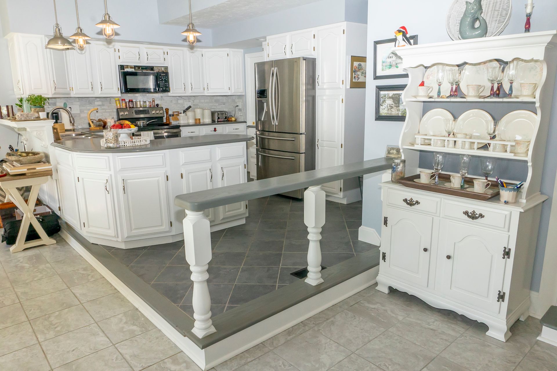 A kitchen with white cabinets , stainless steel appliances , and a hutch.