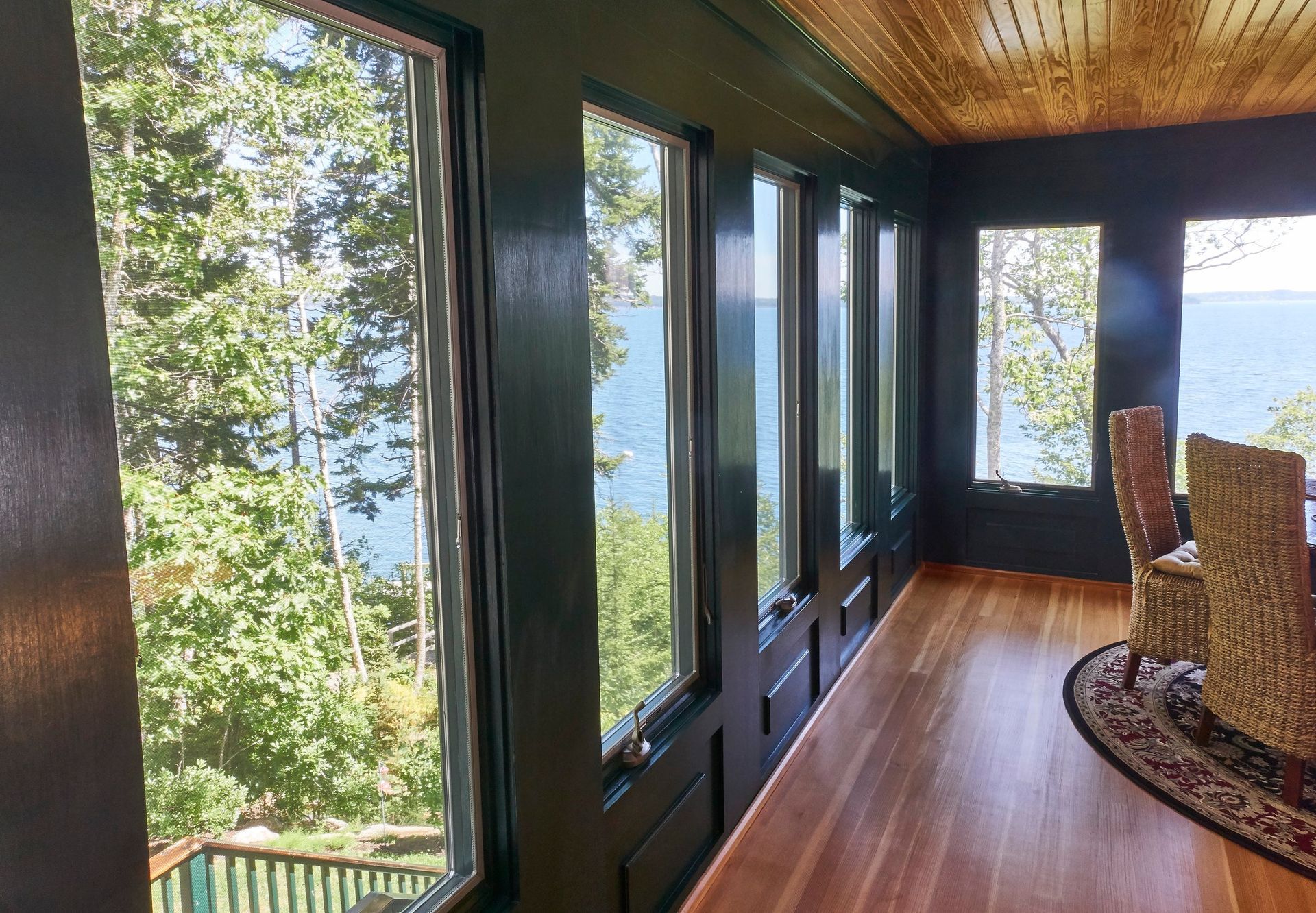 A room with a lot of windows and a view of the ocean.