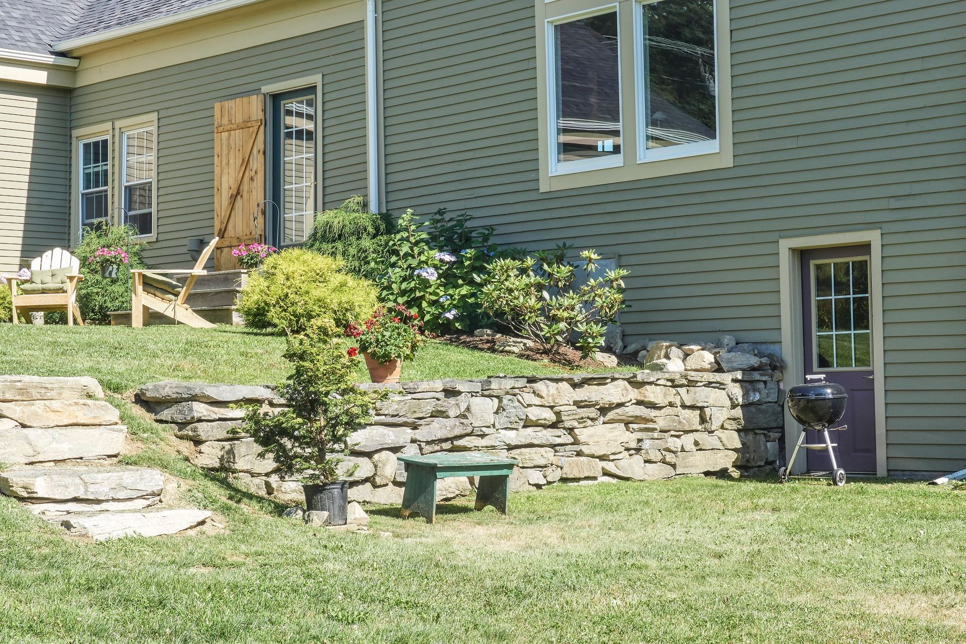 A house with a stone wall in front of it
