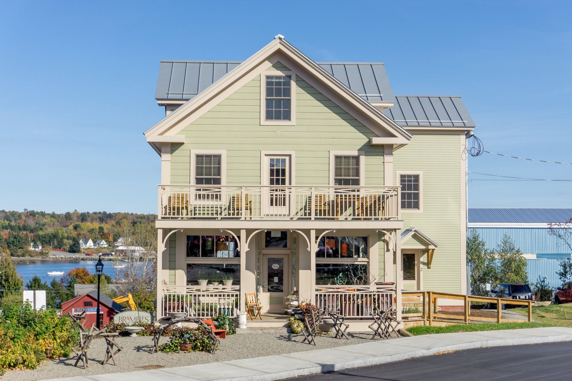 A large green house with a balcony and a fence in front of it.