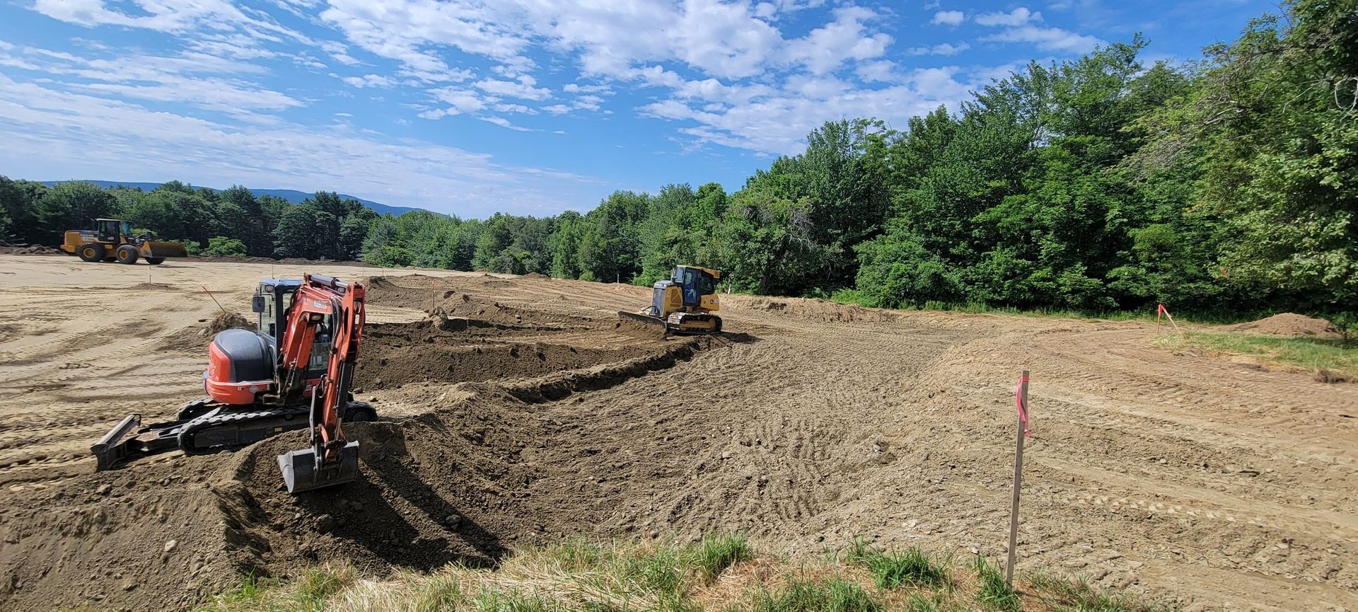 A bobcat tractor is driving through a dirt field.