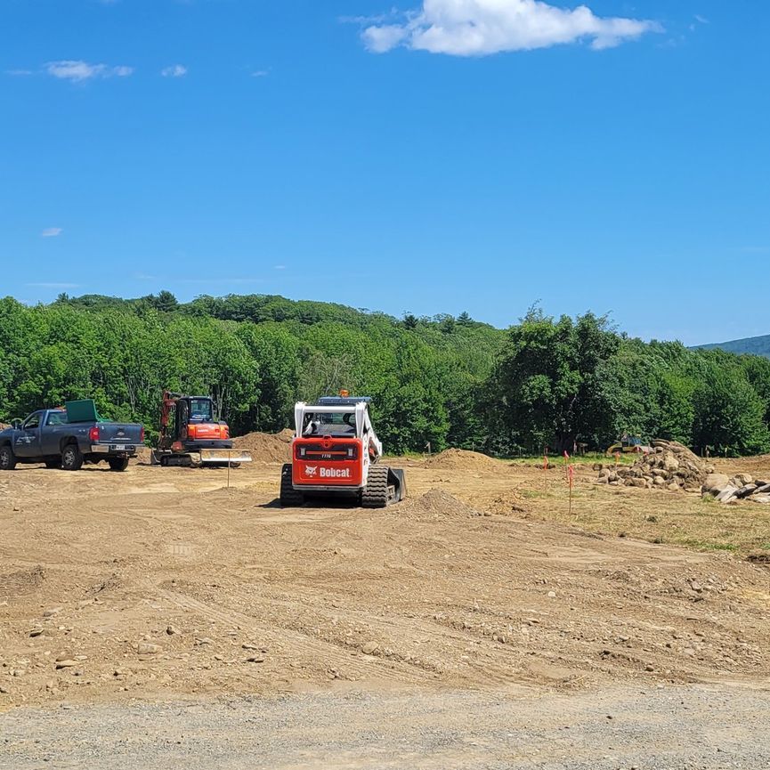 A bobcat tractor is getting the land ready for new construction