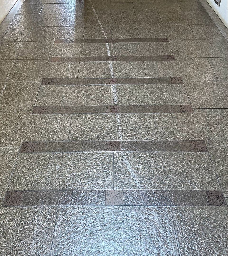 A close up of a tiled floor with a row of steps.