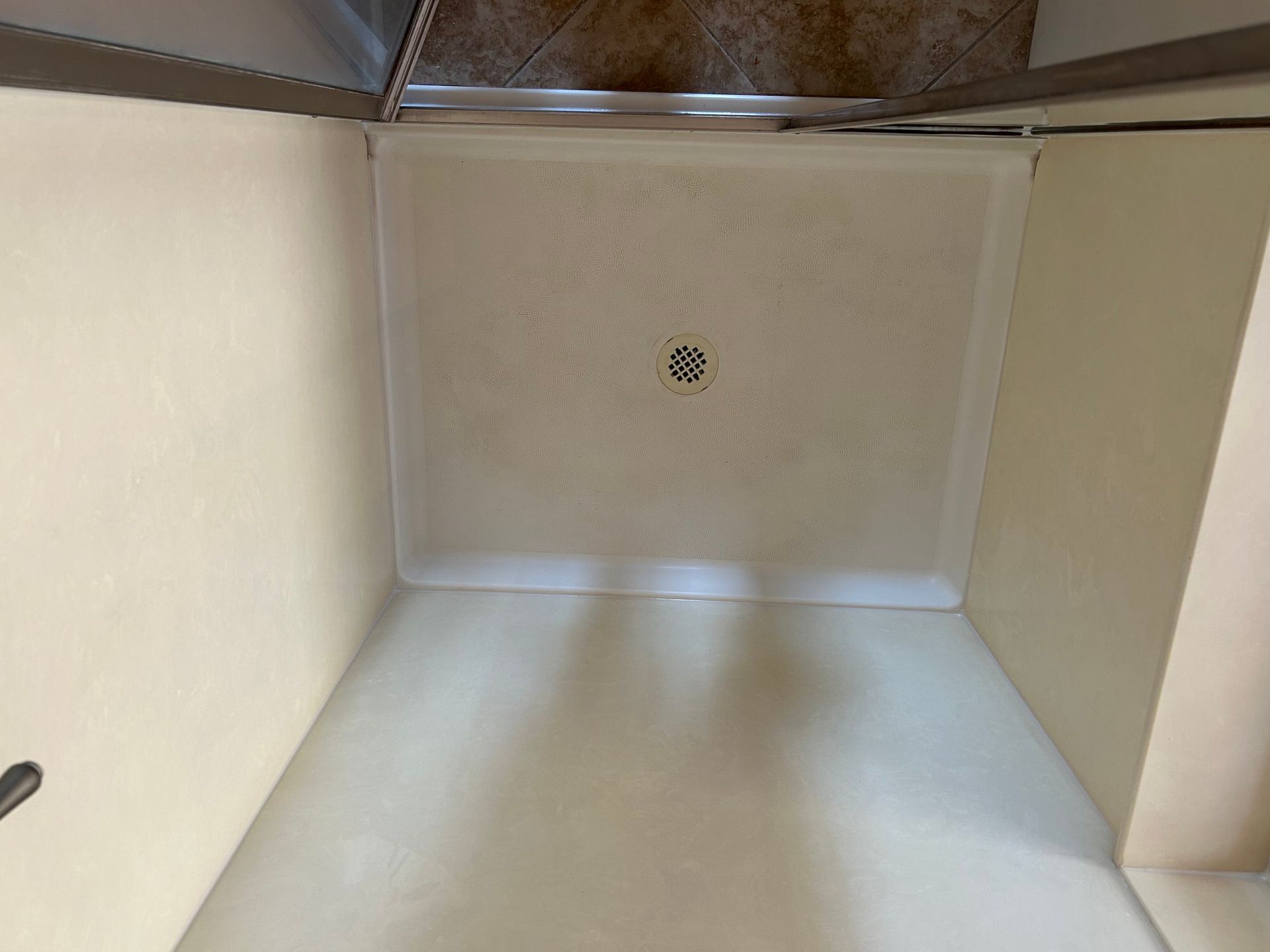 A kitchen with a tiled floor and a stainless steel oven.