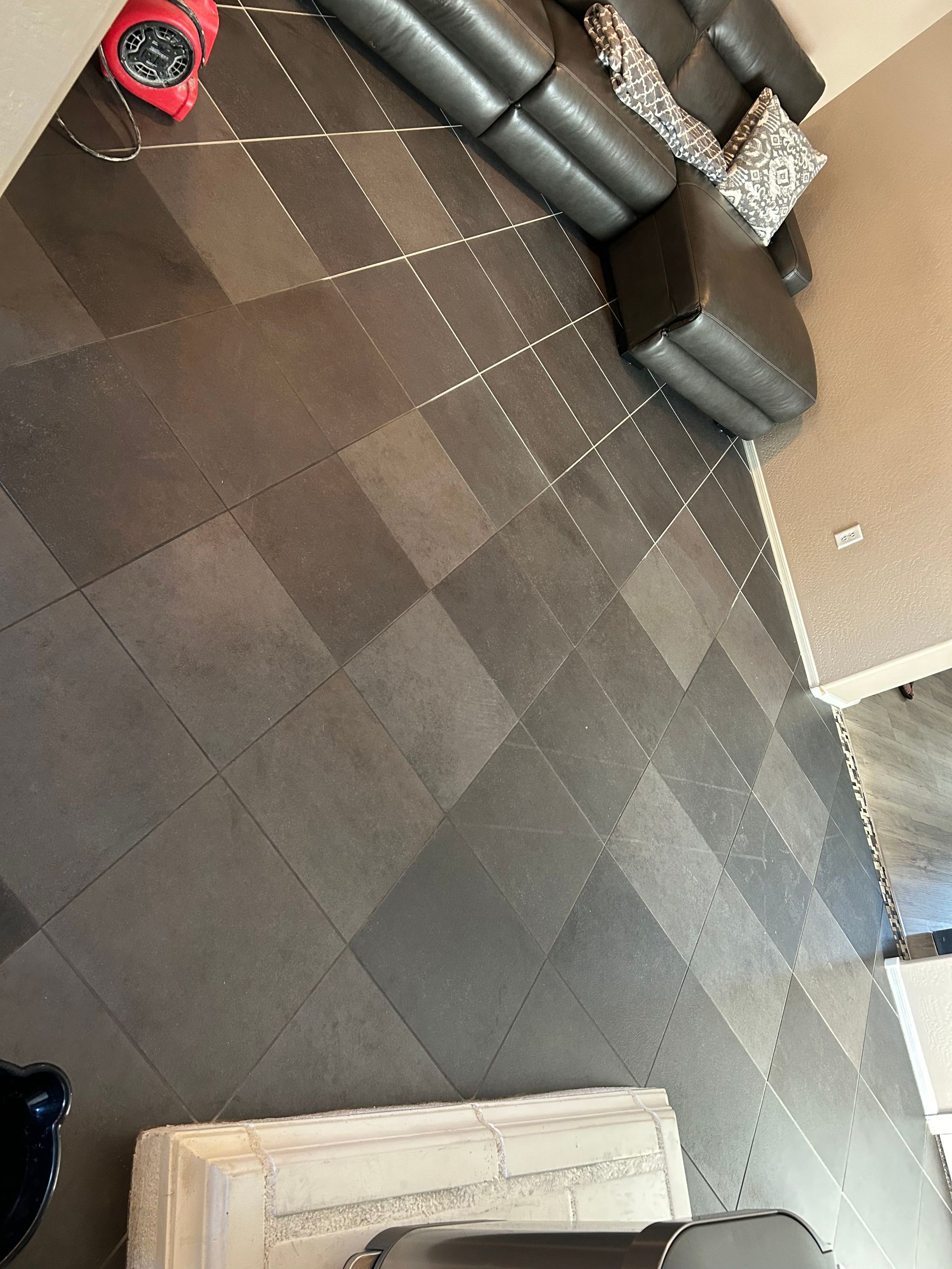 A toilet is sitting on a tiled floor in a bathroom.