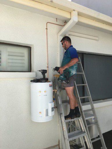 Plumber installing hot water system - Darwin