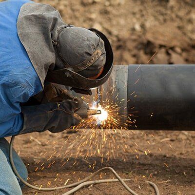a plumber fixing oil/water industrial pipe - Plumbers in Darwin, NT