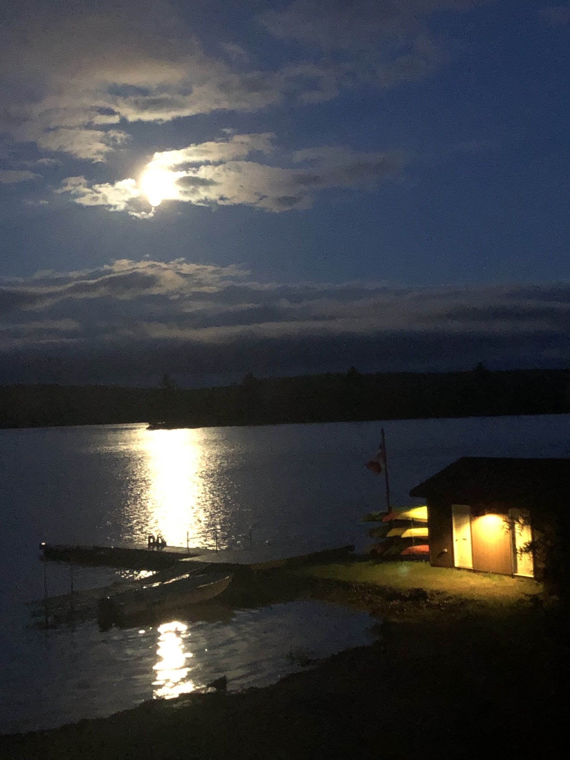 A full moon shines over a body of water