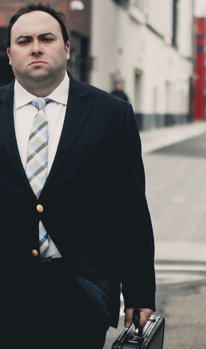 A man in a suit and tie is carrying a briefcase