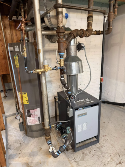 Water heater and furnace with connected pipes and vent in a utility room.