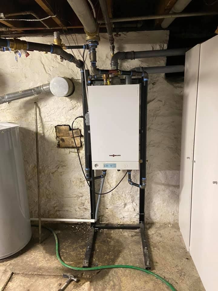 Wall-mounted tankless water heater installed as part of residential HVAC system upgrade