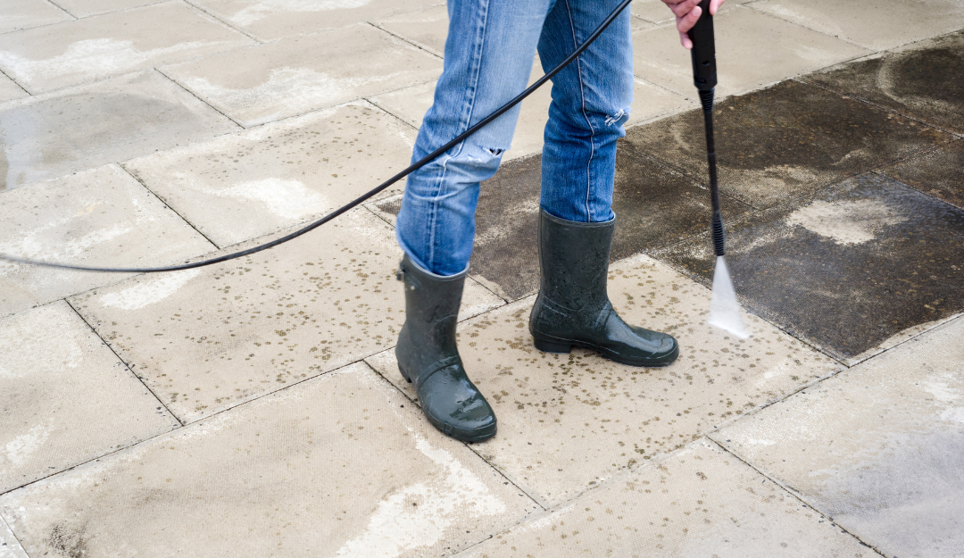 A picture of someone pressure washing tiles with boots on in Mandeville, LA