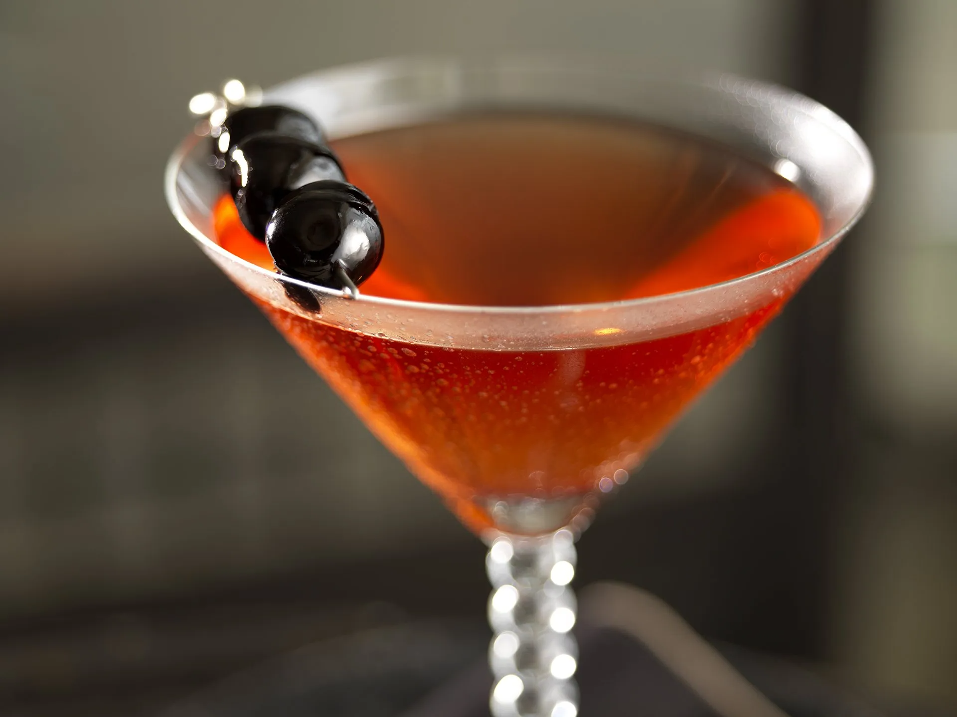 A martini with a cherry on top of it