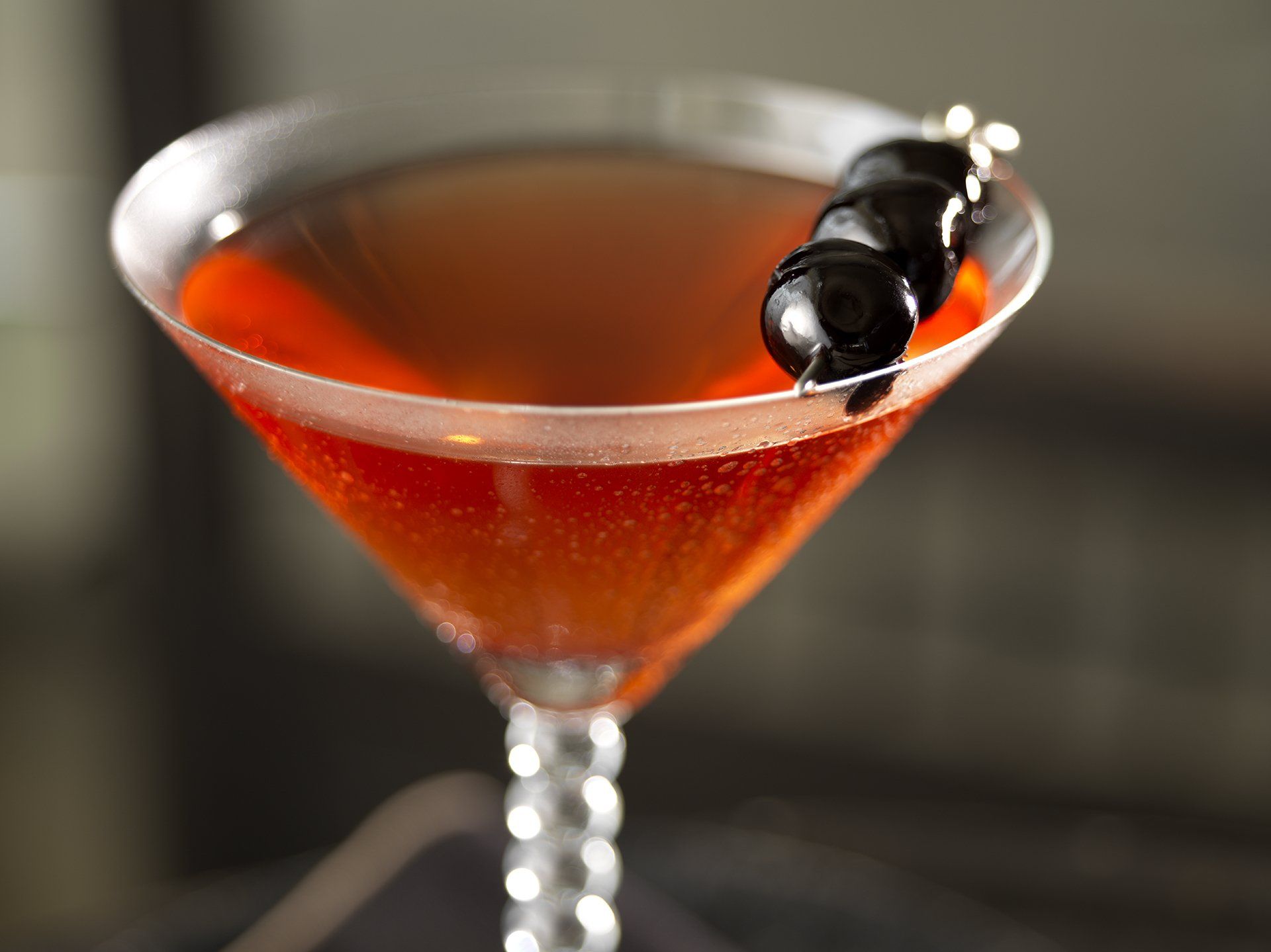 A martini with a cherry on top of it