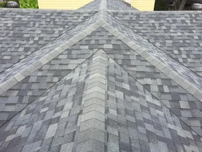 Gray asphalt shingle roof, with a defined ridge and angled surfaces.