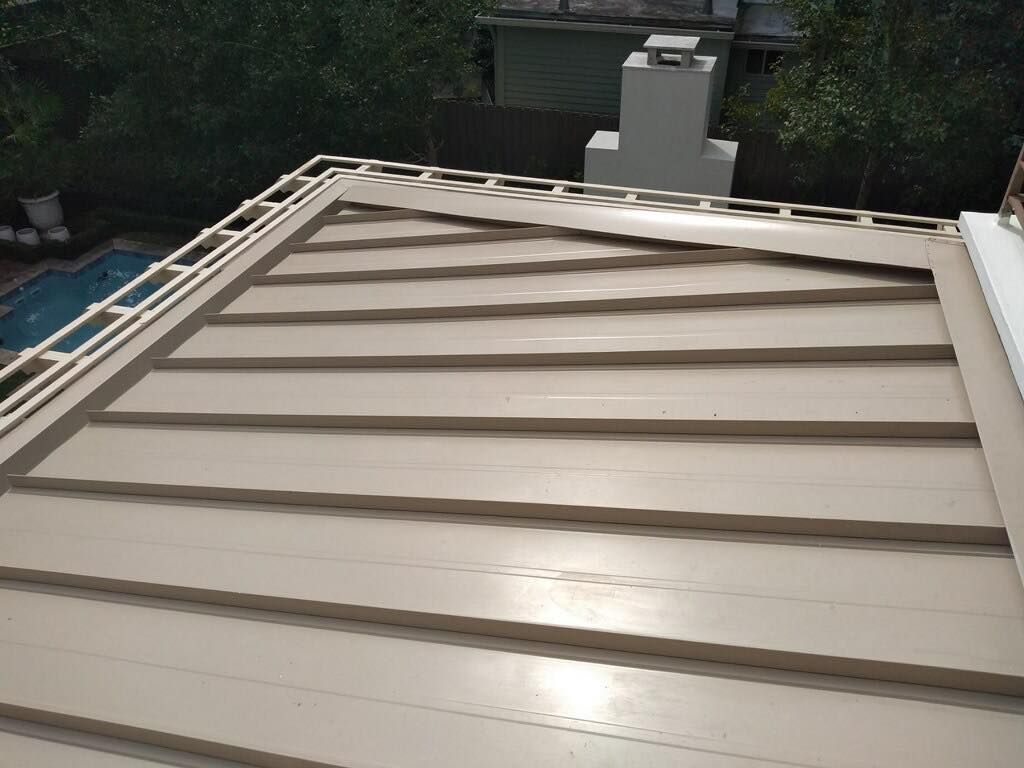 Beige metal roof with horizontal lines, a chimney in the background, and a pool visible to the left.