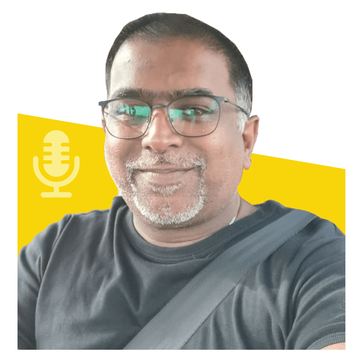 Man with glasses and a black shirt, smiling, in front of a yellow and white backdrop with a microphone icon.