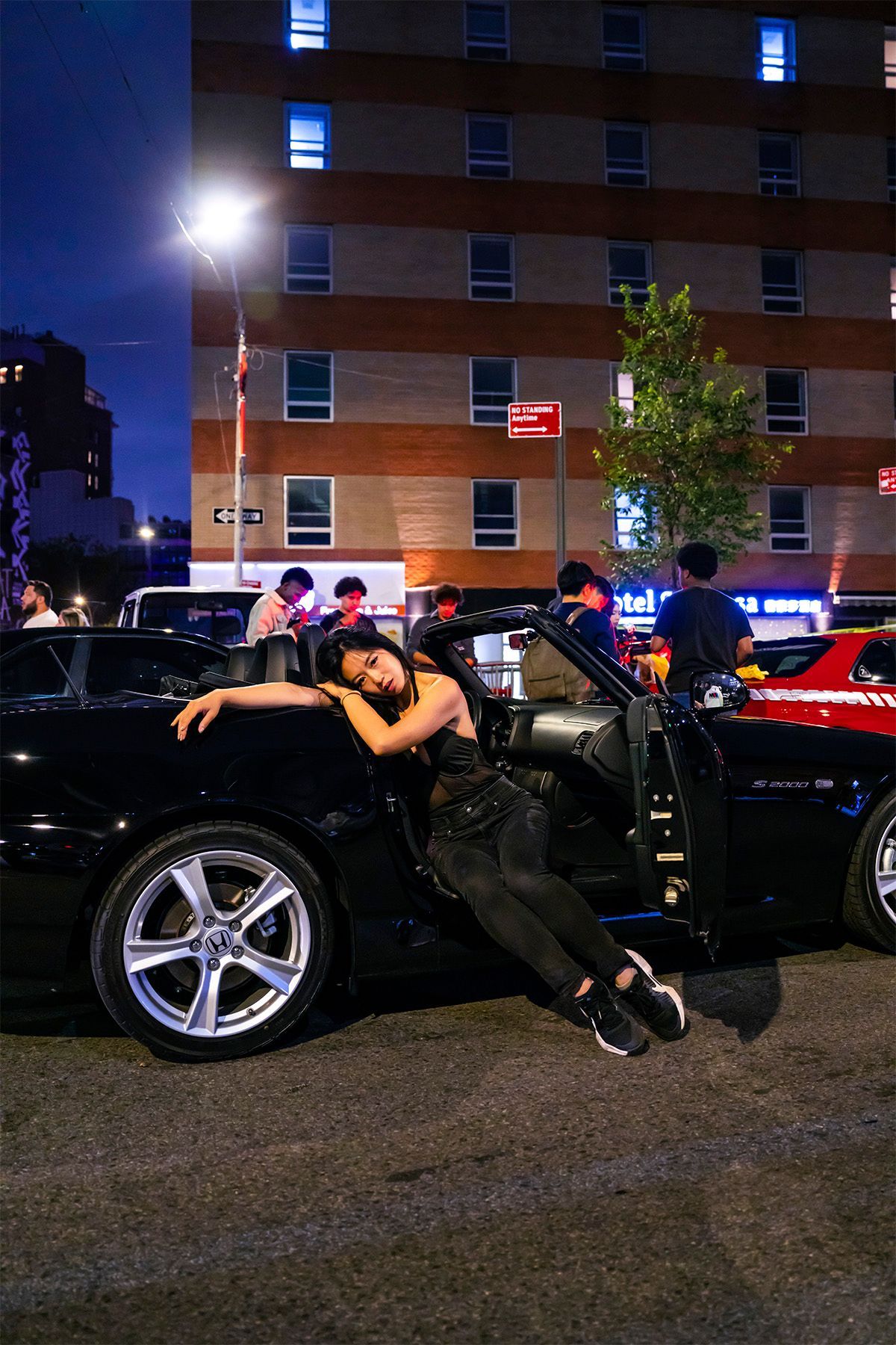 Minnie Lee — NYC car model leaning on  a car at  NYC Chinatown Daikoku car meet, photography portrait by Josanna Uy.