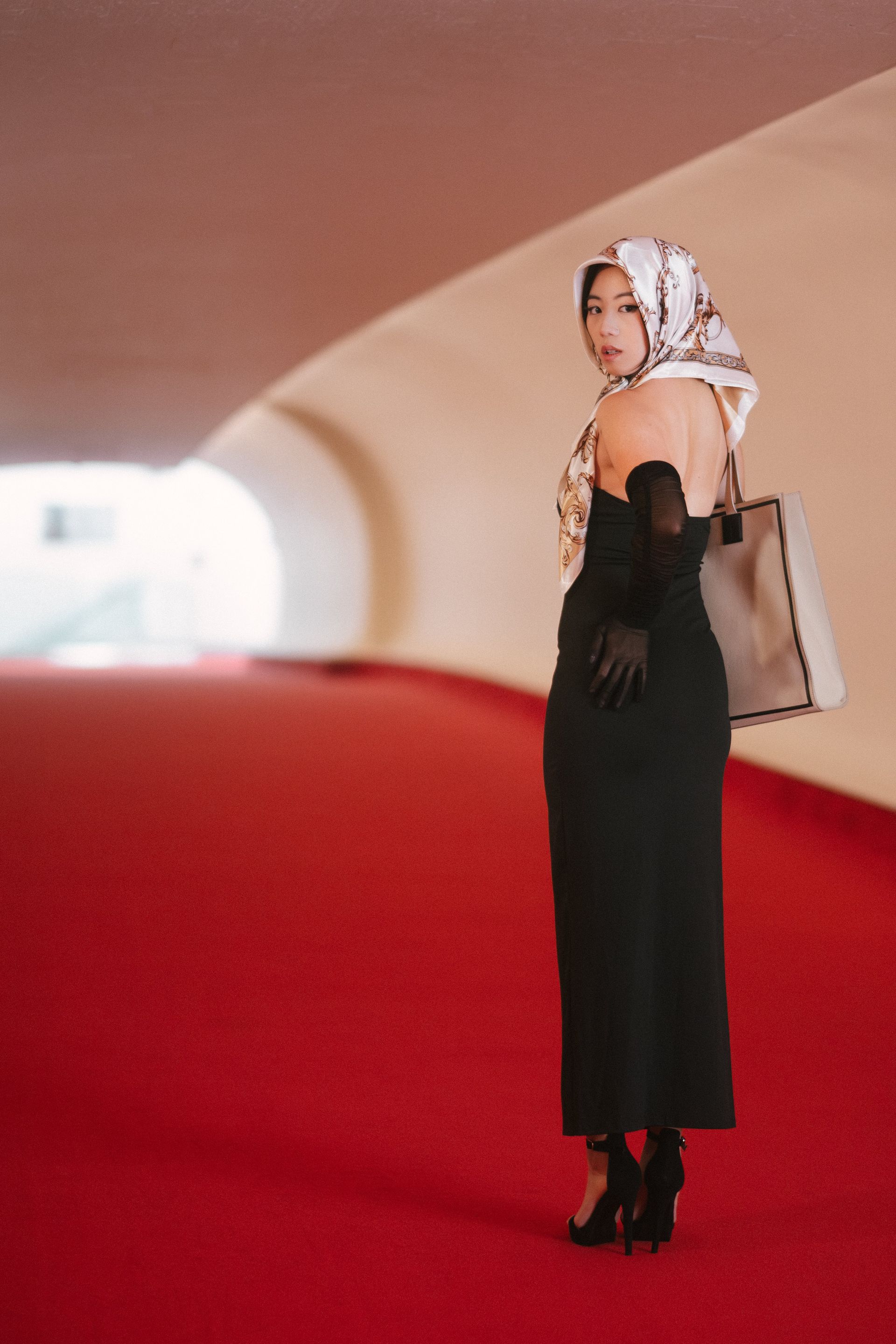 Luxury editorial model with elegant posture and narrative presence — photographed at the TWA Hotel, midcentury cinematic atmosphere — Minnie Lee.