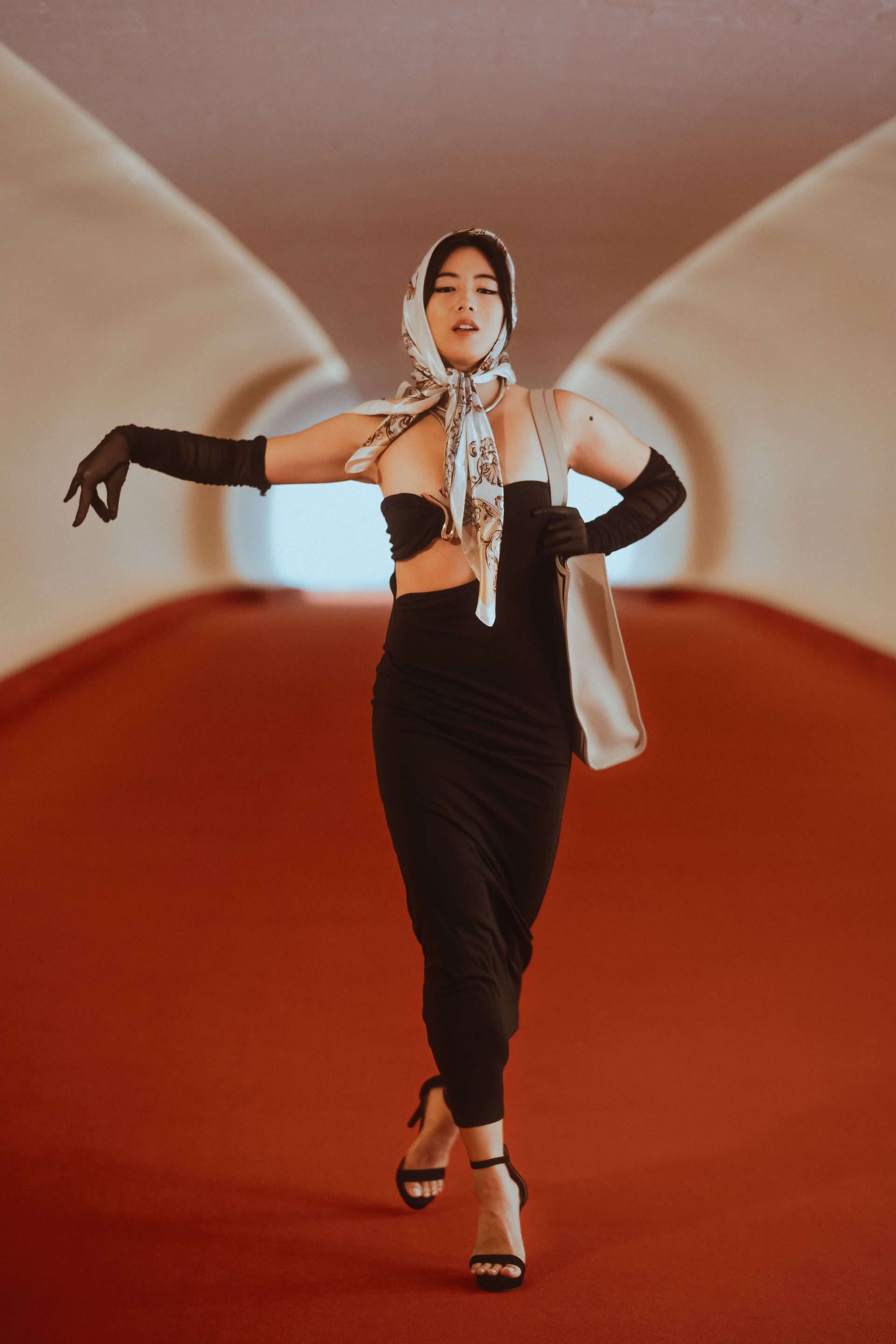 Luxury editorial model with elegant posture and narrative presence — photographed at the TWA Hotel, midcentury cinematic atmosphere — Minnie Lee.