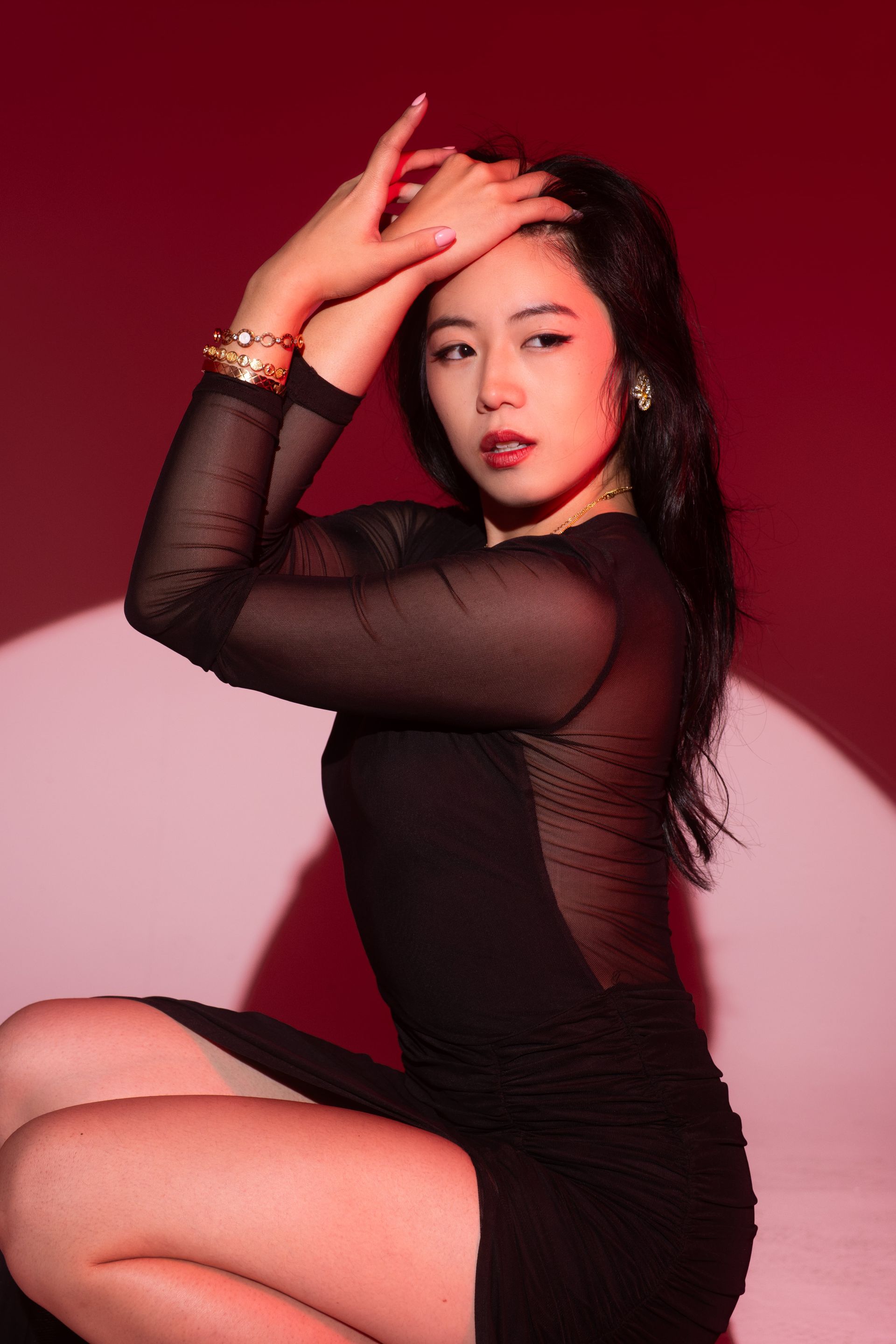 Ballet-trained control and precision, red backdrop discipline series, commanding stillness and emotional intelligence — model Minnie Lee.
