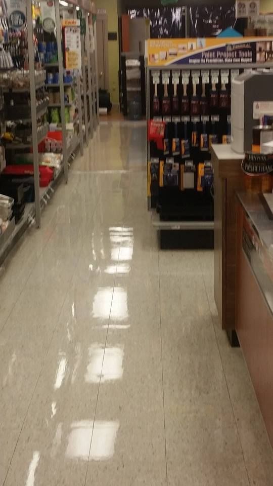 A store aisle with lots of shelves and a counter.