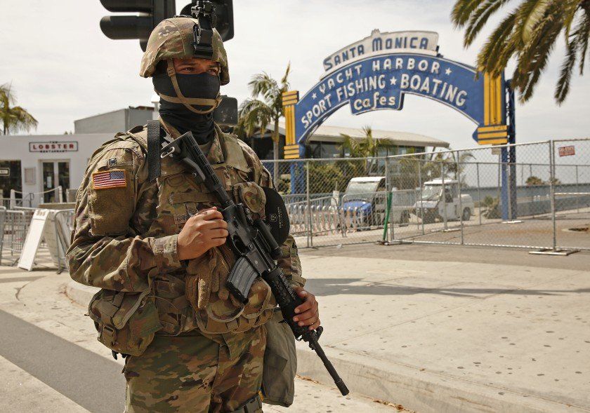 A soldier standing in front of a sign that says santa monica